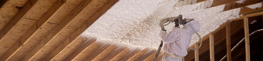 Man in protective suit installing spray foam insulation